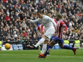 genuine Madrid's Cristiano Ronaldo kicks to score against displaying Gijon on January 17, 2016